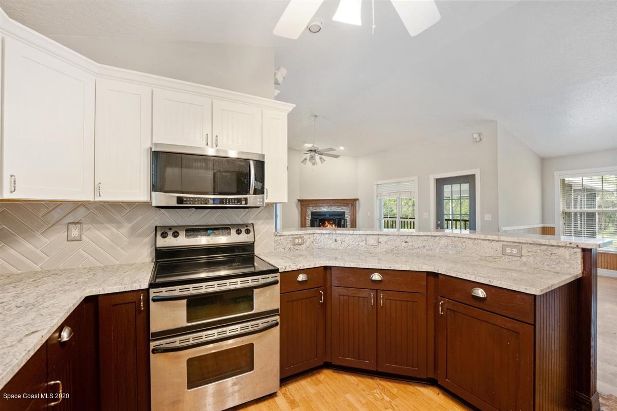 5551 Senne Road Micco, FL 32976 - Photo 8 of 37 a kitchen with granite countertop a stove and a sink