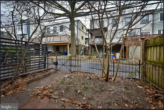 a view of a house with a small yard and a large tree