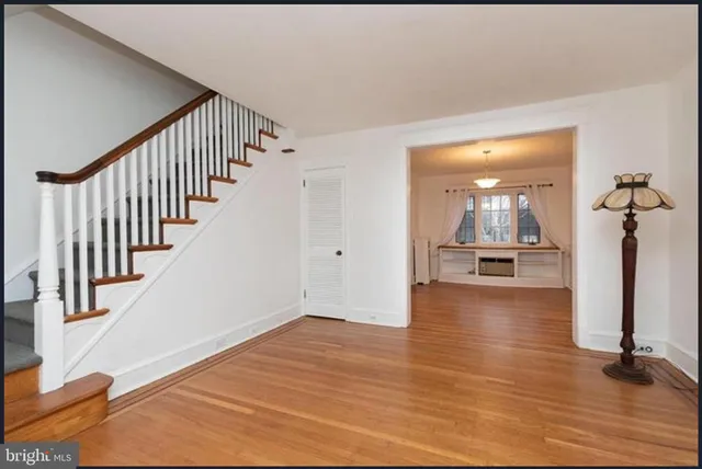 a view of a hallway with wooden floor and staircase