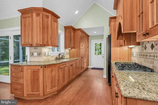 a kitchen with stainless steel appliances granite countertop a stove a sink and a refrigerator