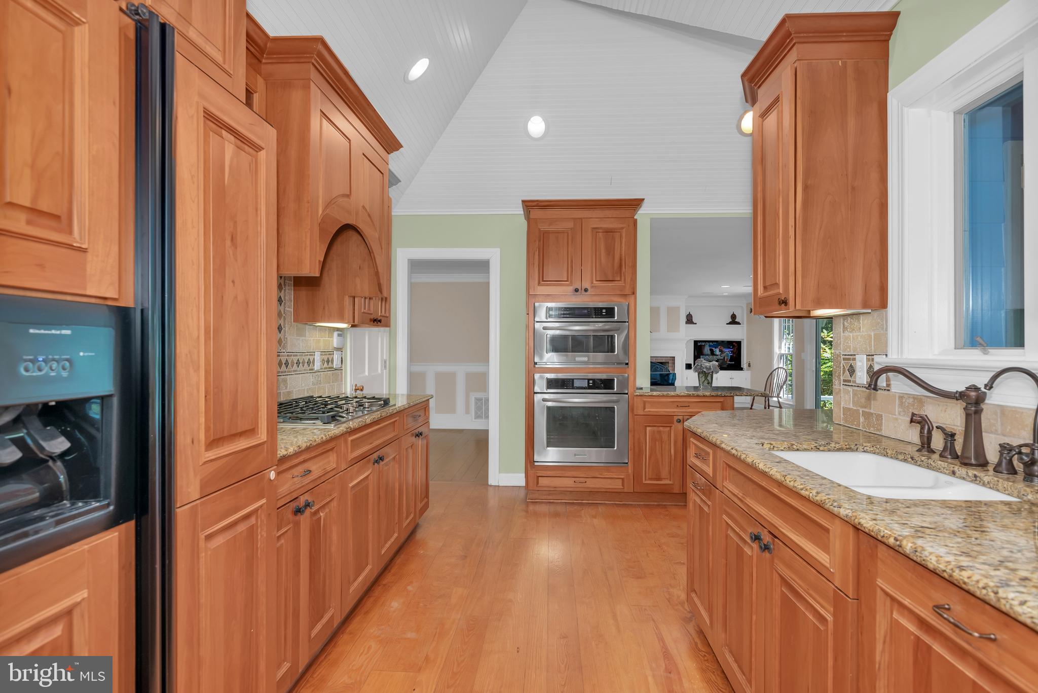 24420 Mallard Place St. Michaels, MD 21663 - Photo 19 of 33 a kitchen with stainless steel appliances granite countertop a sink and wooden cabinets