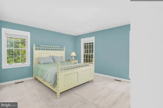 a bed sitting in a bedroom next to a window