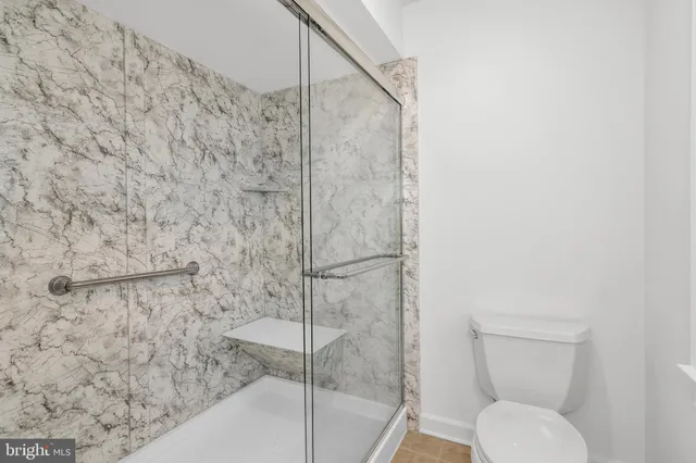 a bathroom with a toilet and a shower