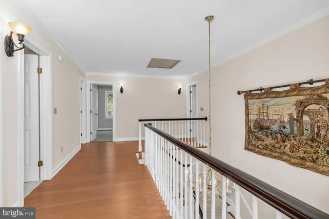 a view of a hallway with wooden floor and staircase