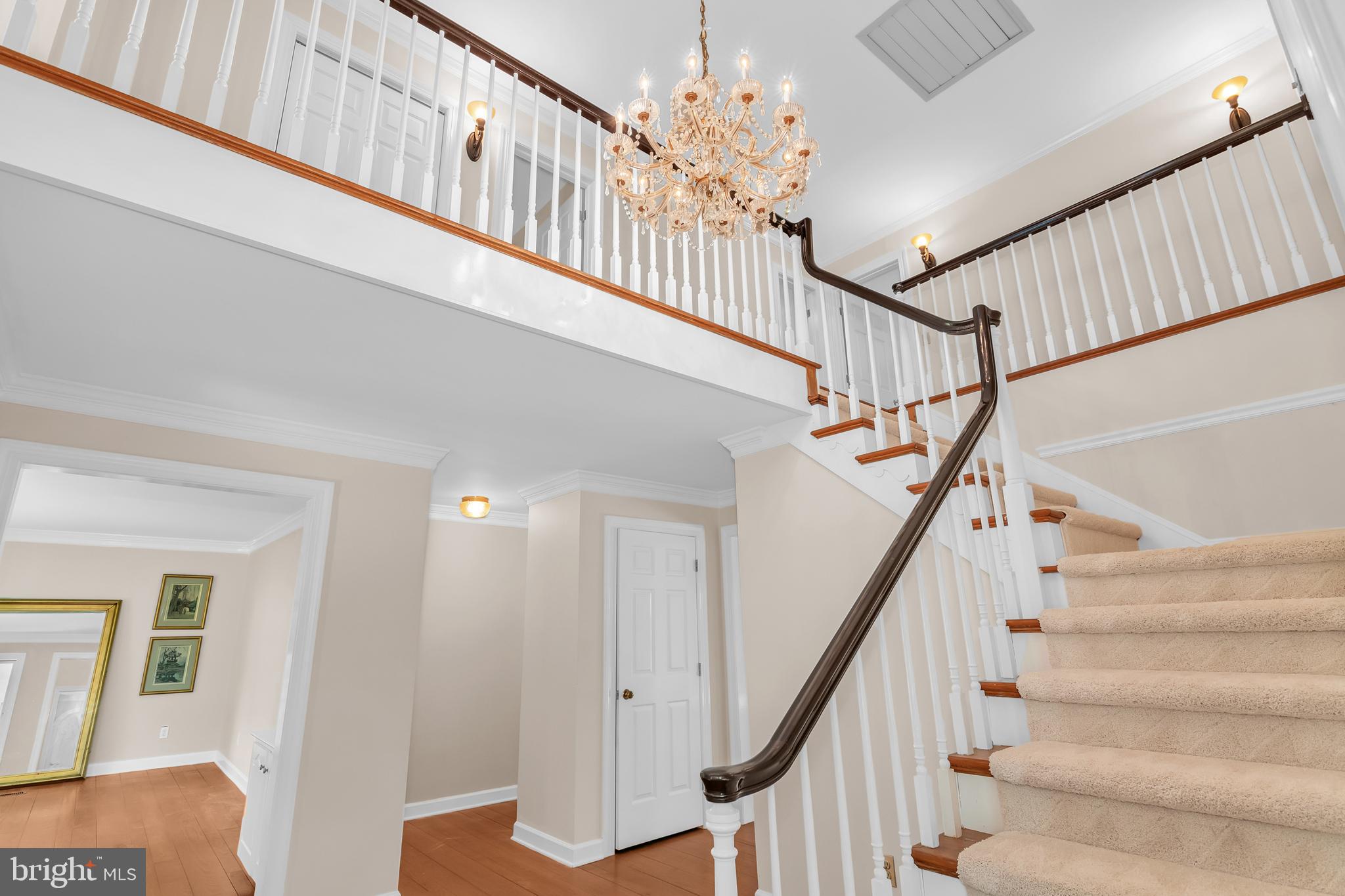 24420 Mallard Place St. Michaels, MD 21663 - Photo 7 of 33 a view of staircase with lots of frames on wall and wooden floor