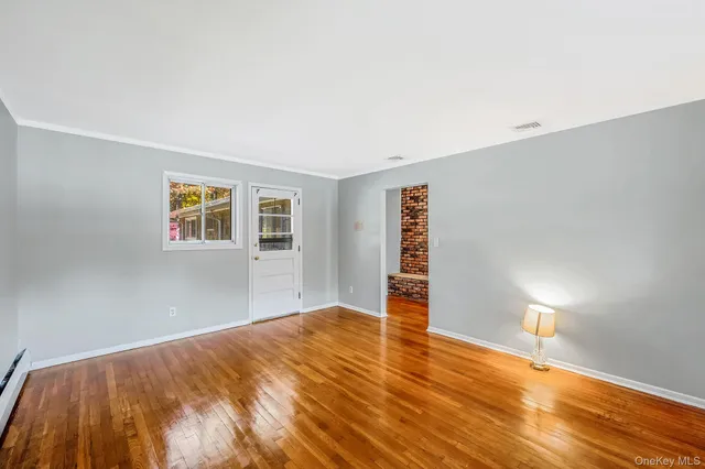 a view of empty room with wooden floor
