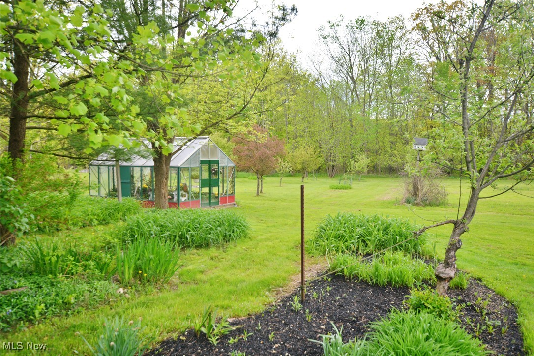 16140 Thompson Road Thompson, OH 44086 - Photo 16 of 50 View of green lawn with an exterior structure and an outdoor structure