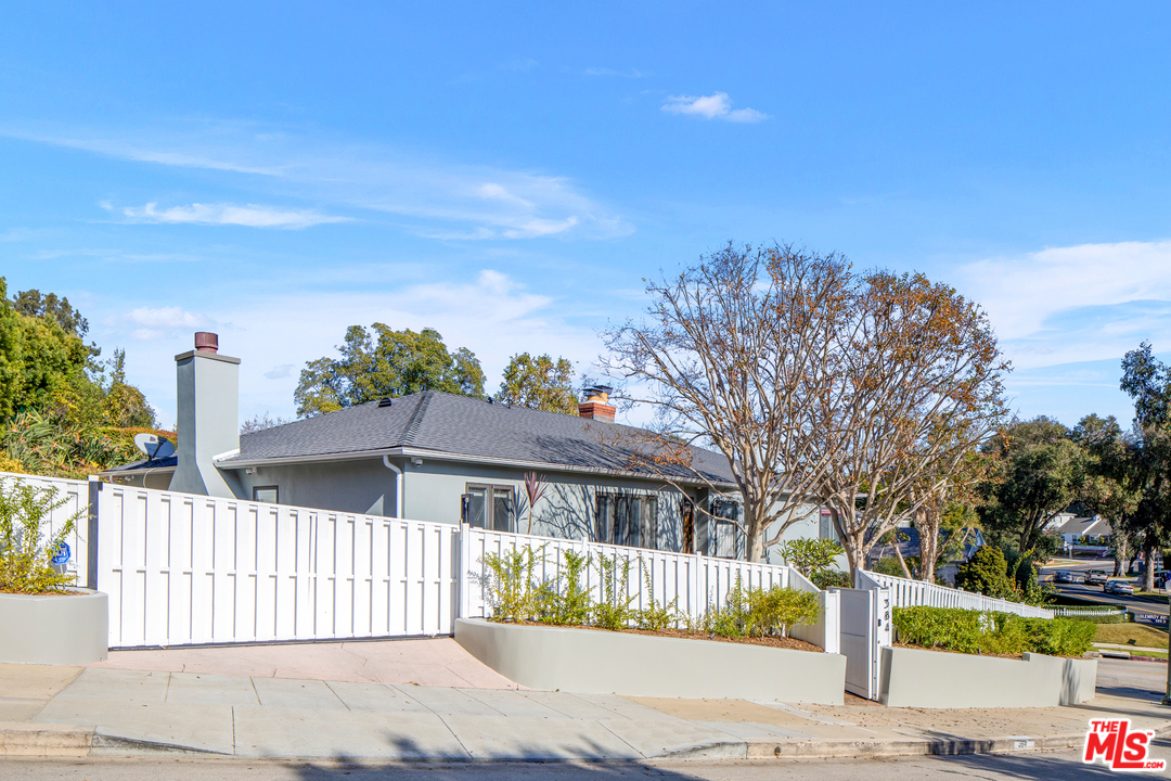 384 Dalkeith Avenue Los Angeles, CA 90049 - Photo 2 of 37 a front view of a house with a garden
