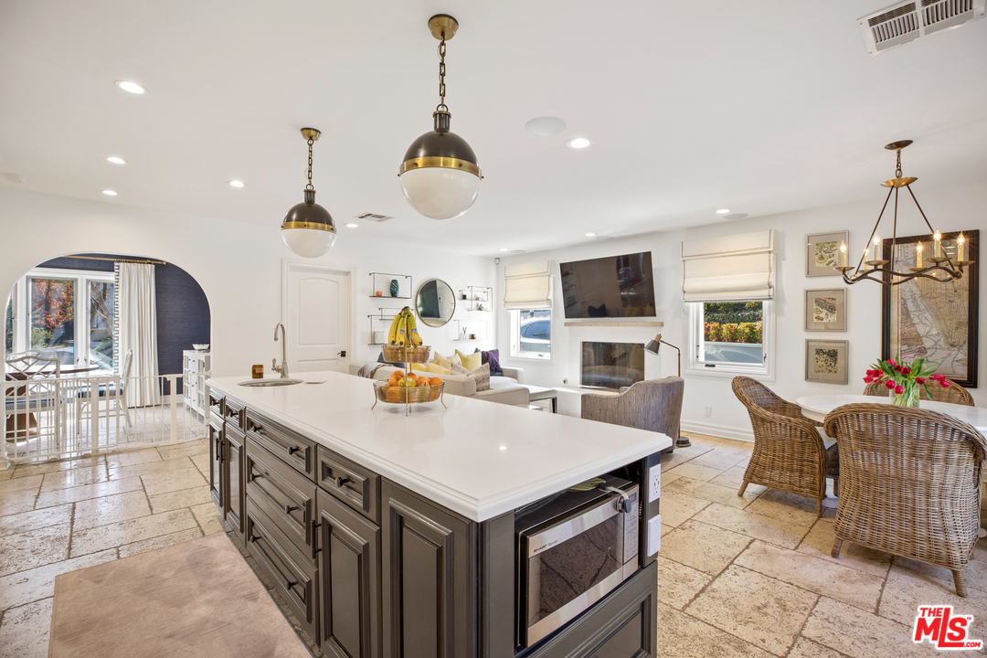 384 Dalkeith Avenue Los Angeles, CA 90049 - Photo 20 of 37 a open kitchen with stainless steel appliances granite countertop a stove top oven a sink dishwasher a dining table and chairs with wooden floor