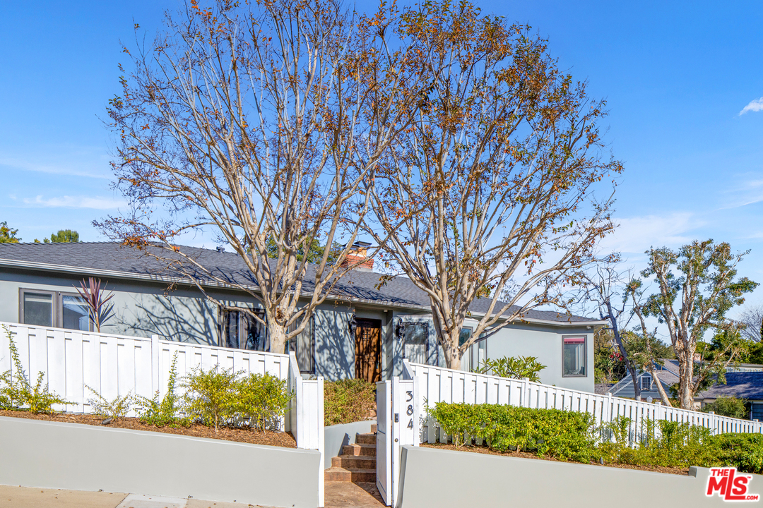 384 Dalkeith Avenue Los Angeles, CA 90049 - Photo 3 of 37 a front view of a house with a yard
