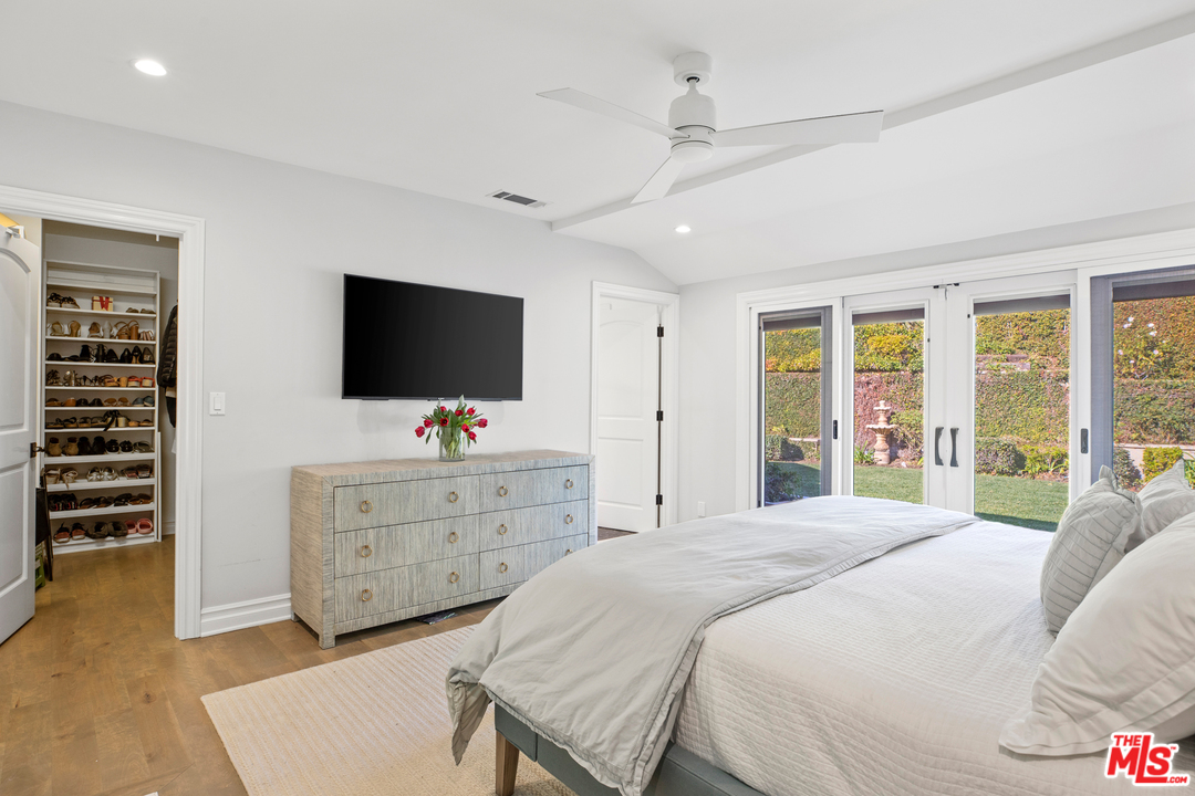 384 Dalkeith Avenue Los Angeles, CA 90049 - Photo 28 of 37 a bedroom with a bed and a flat screen tv