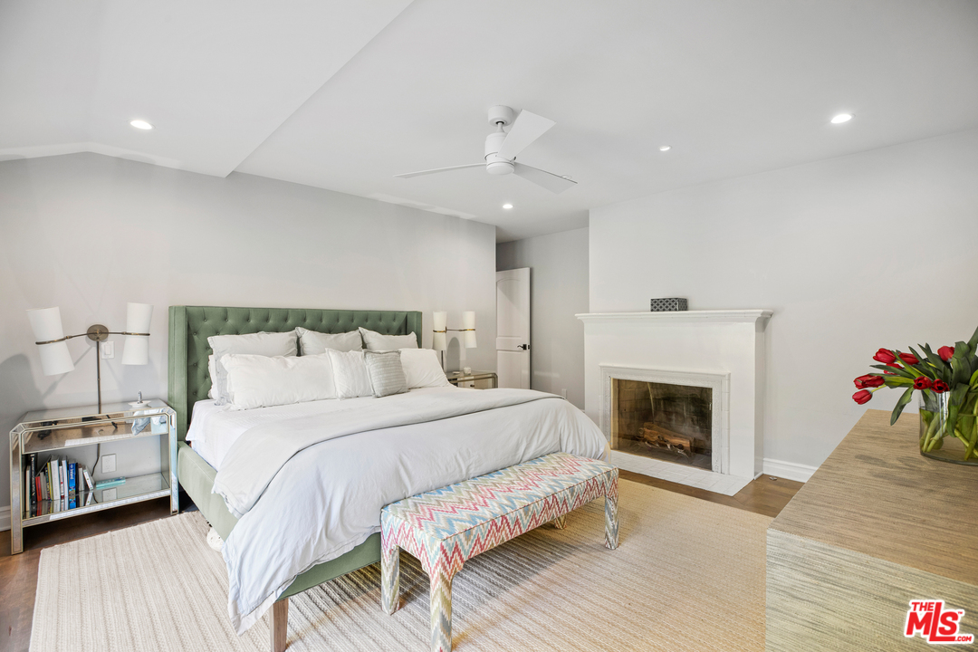 384 Dalkeith Avenue Los Angeles, CA 90049 - Photo 29 of 37 a bed room with a bed and a fireplace