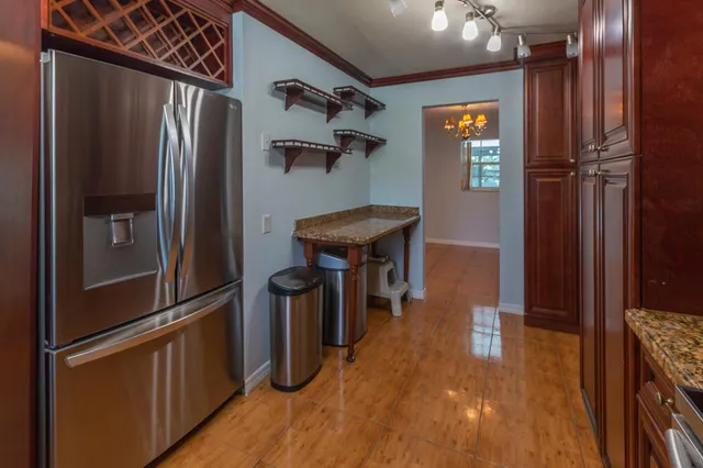 a kitchen with stainless steel appliances granite countertop a refrigerator and a stove