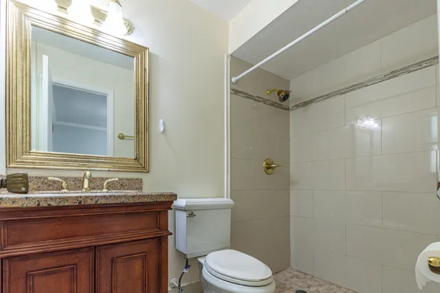 a bathroom with a sink vanity mirror and toilet