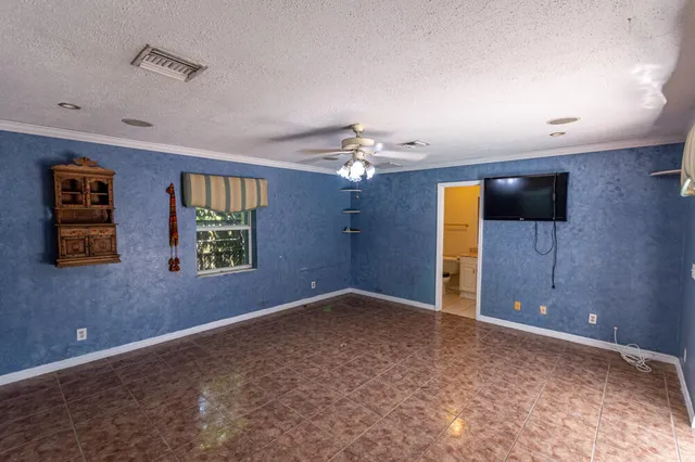 en empty room with windows and chandelier