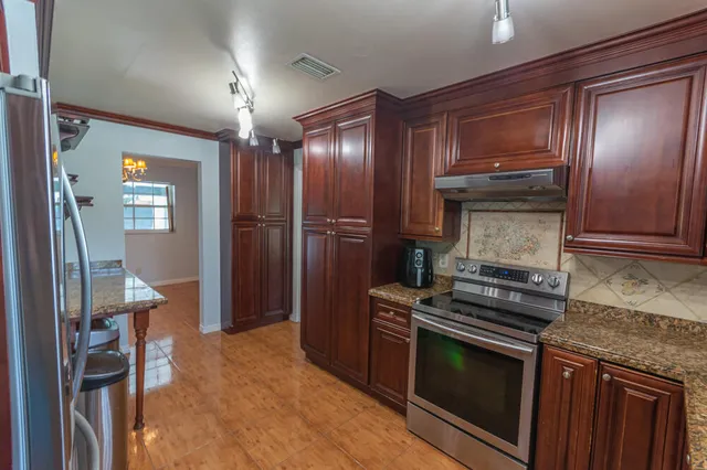 a kitchen that has a sink stainless steel appliances and cabinets