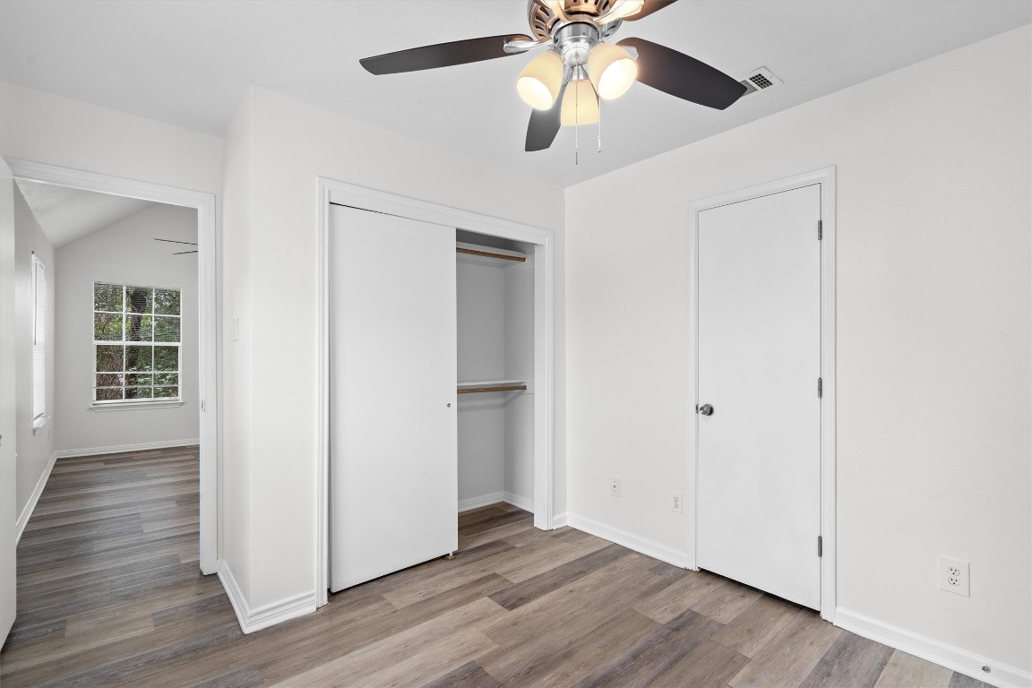 2908 Whisper Oaks Lane, Unit C Georgetown, TX 78628 - Photo 19 of 31 an empty room with wooden floor chandelier fan and windows