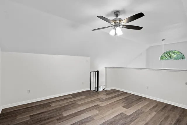 a view of a room with wooden floor and a ceiling fan