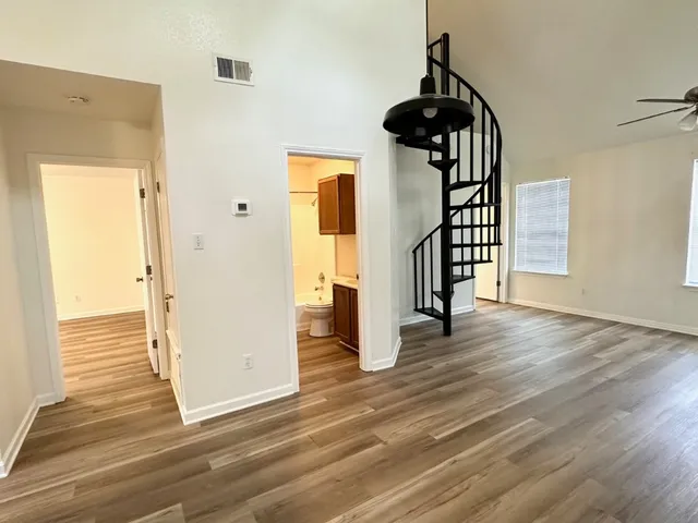a view of a hallway with wooden floor and staircase