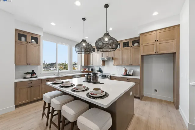 a open kitchen with stainless steel appliances kitchen island a table and chairs in it