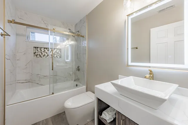 a bathroom with a sink a toilet and shower