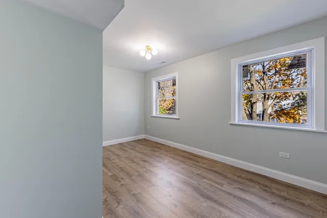 an empty room with wooden floor and window