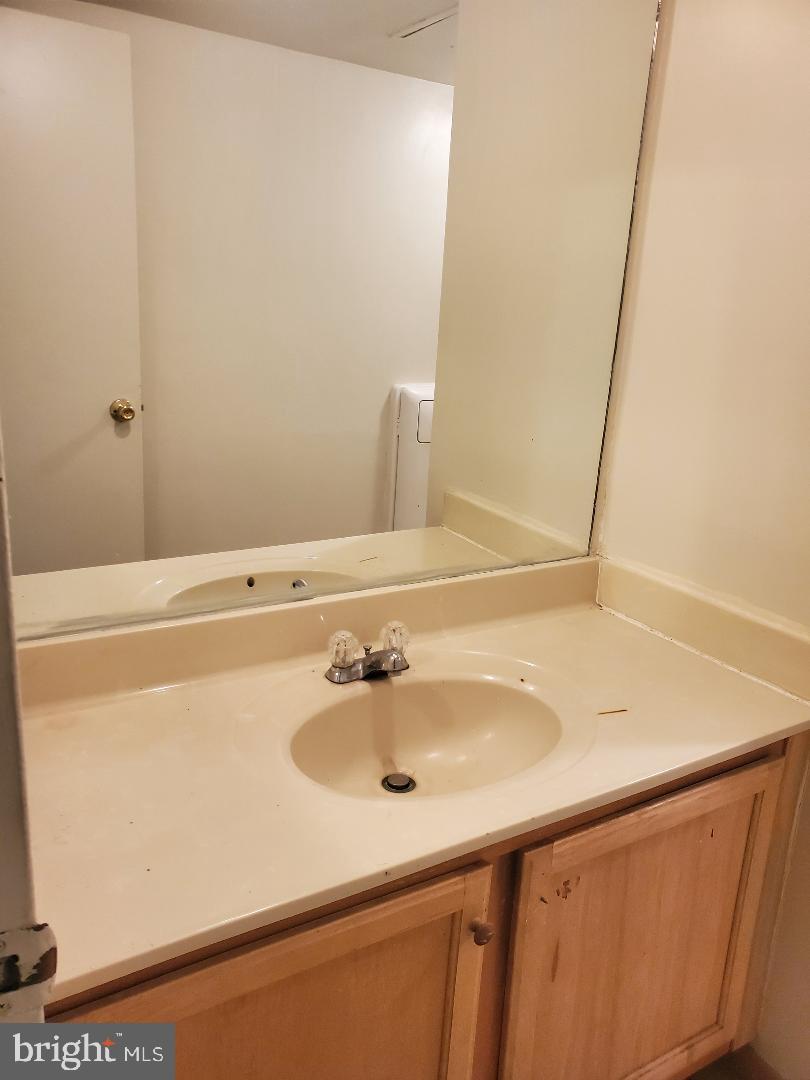 8481 Greenbelt Road, Unit T2 Greenbelt, MD 20770 - Photo 22 of 22 a bathroom with a sink and a mirror