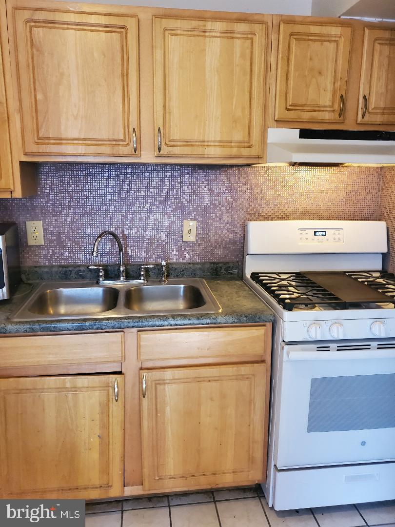 8481 Greenbelt Road, Unit T2 Greenbelt, MD 20770 - Photo 6 of 22 a kitchen with stainless steel appliances granite countertop a sink stove and cabinets