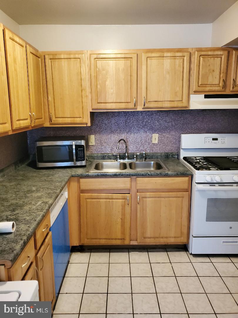 8481 Greenbelt Road, Unit T2 Greenbelt, MD 20770 - Photo 9 of 22 a kitchen with stainless steel appliances granite countertop a sink stove and cabinets