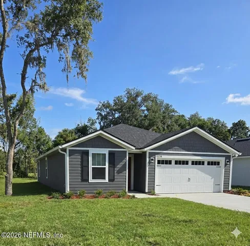 a front view of a house with a yard and trees