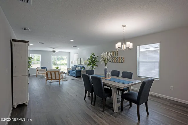 a view of a dining room with furniture and chandelier