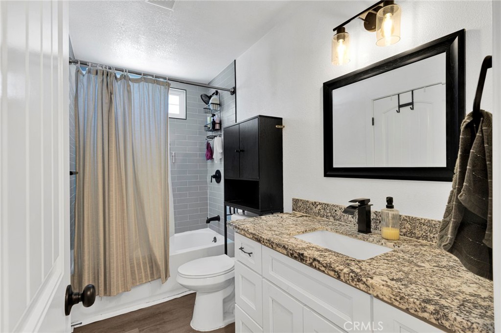15471 Washoan Road Apple Valley, CA 92307 - Photo 15 of 38 a bathroom with a granite countertop sink toilet and shower