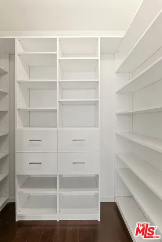 a view of walk in closet with empty racks