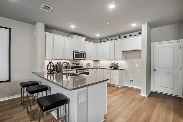 a kitchen with stainless steel appliances kitchen island granite countertop a sink and a stove top oven