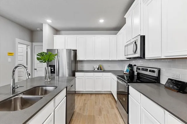 a kitchen with stove a sink and cabinets