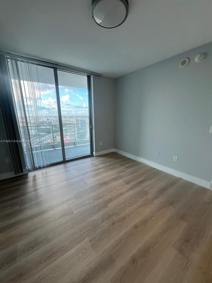 90 Southwest 3rd Street, Unit 4208 Miami, FL 33130 - Photo 13 of 17 wooden floor in an empty room with a window