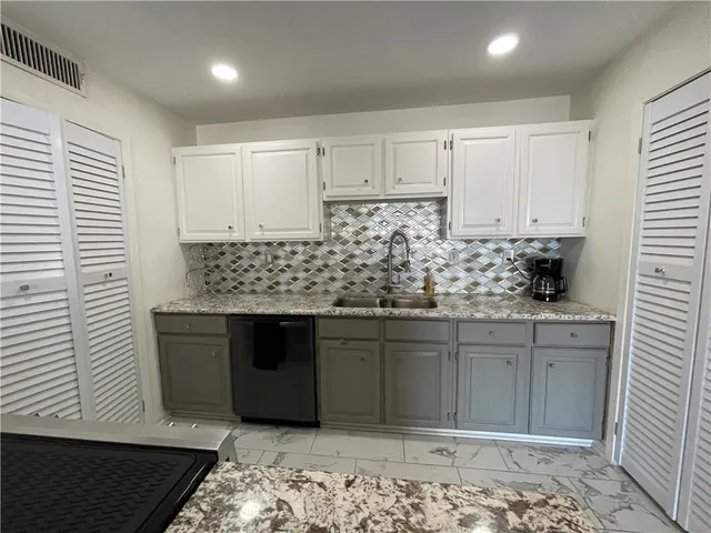a kitchen with stainless steel appliances granite countertop a sink and cabinets