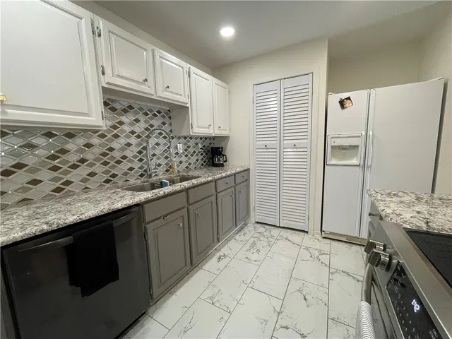 a kitchen with stainless steel appliances granite countertop a sink stove and refrigerator