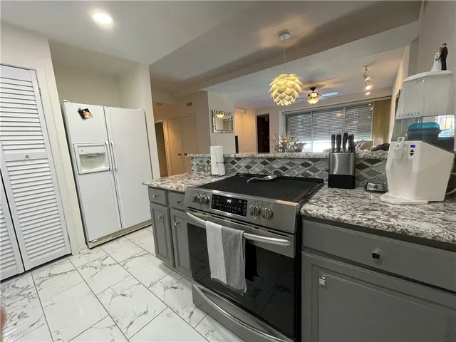 a kitchen with stainless steel appliances granite countertop a stove a sink and a refrigerator