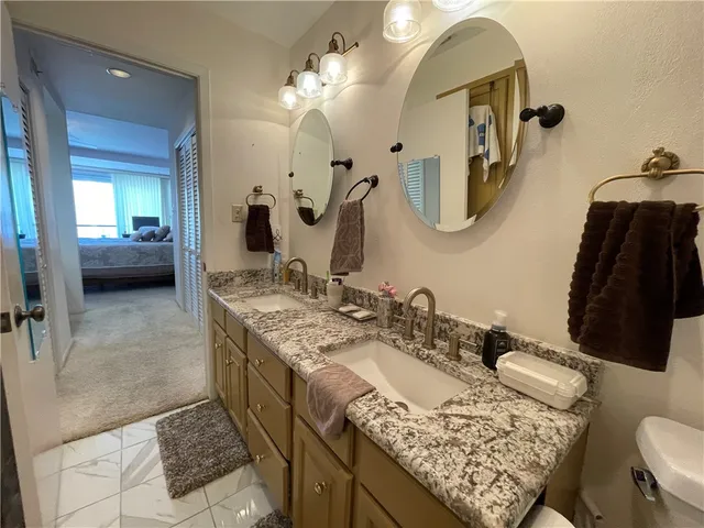 a en suite bathroom with a double vanity sink and a mirror