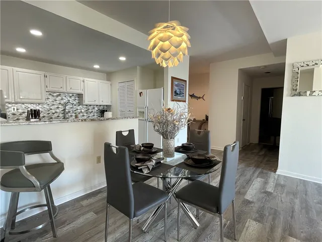 a kitchen with stainless steel appliances kitchen island granite countertop a table and chairs in it