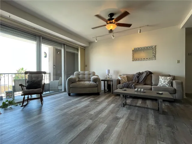 a living room with furniture and a flat screen tv with wooden floor