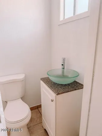 a bathroom with a granite countertop toilet and a sink