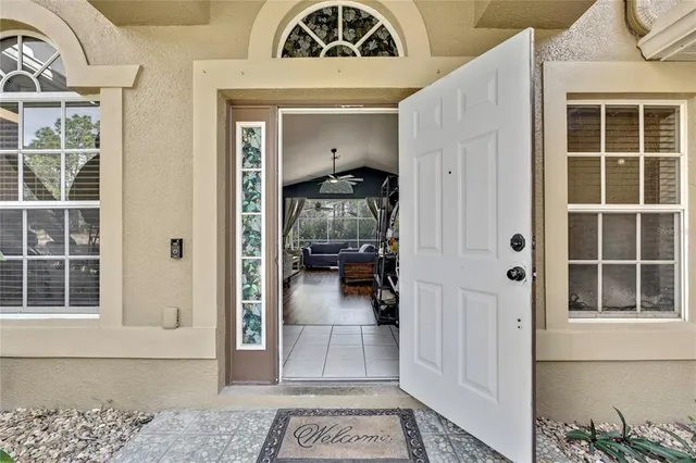 a living room with furniture kitchen view and a chandelier