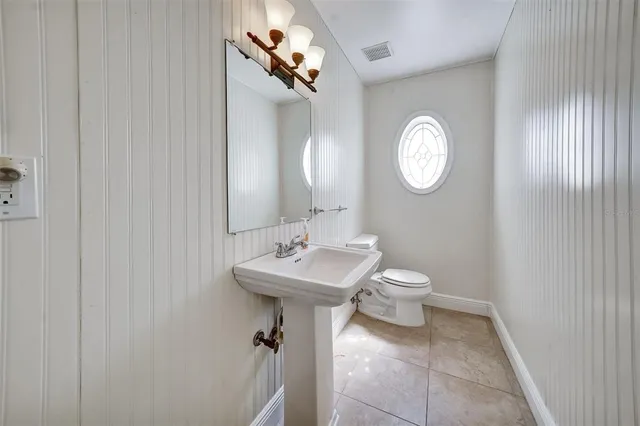 a bathroom with a toilet a sink and a mirror