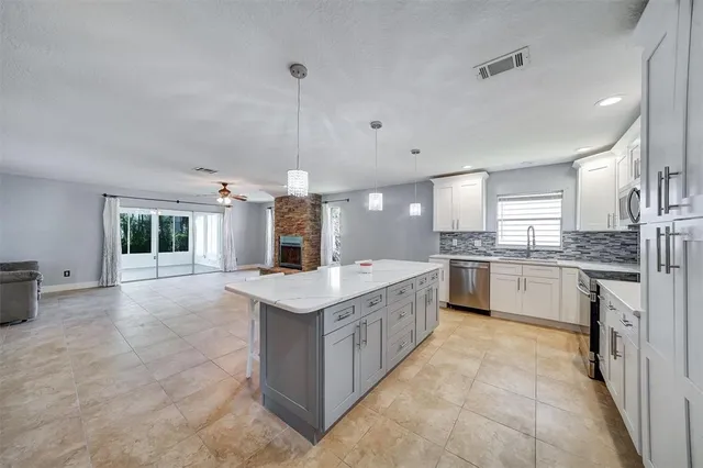 a kitchen with granite countertop a sink counter top space stainless steel appliances and cabinets