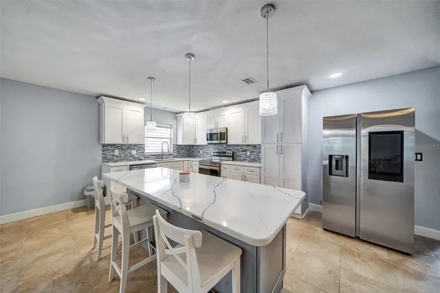 a kitchen with a sink a kitchen island and stainless steel appliances