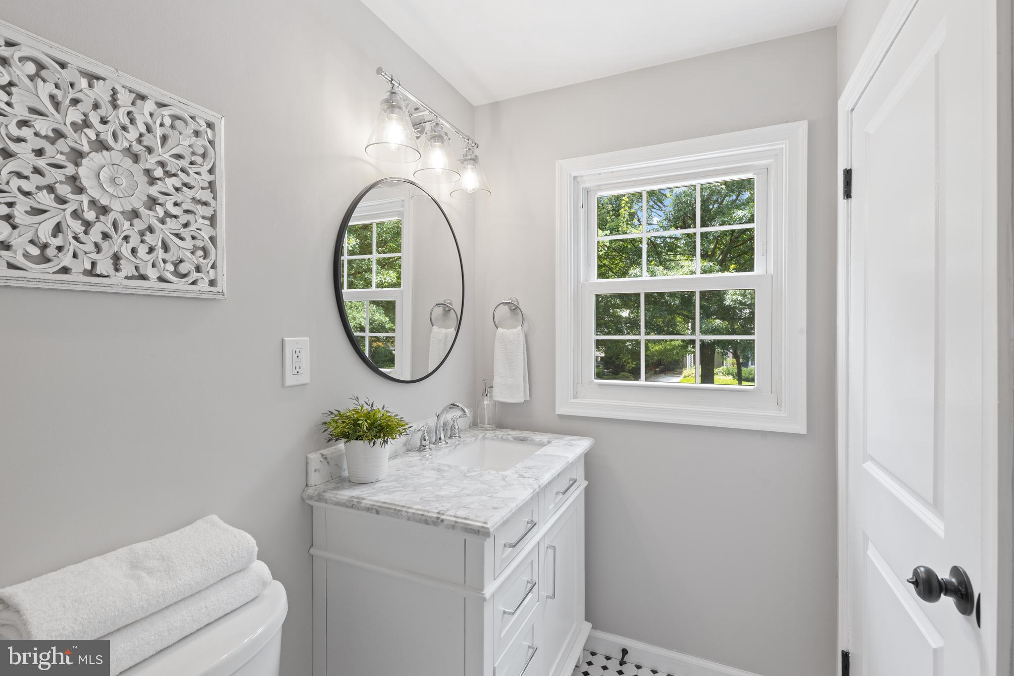7003 Wardman Road Baltimore, MD 21212 - Photo 28 of 42 a bathroom with a granite countertop toilet a sink and a window
