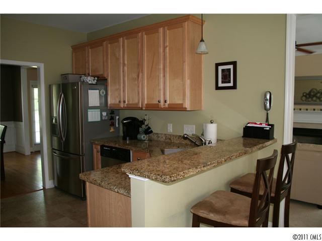1826 Sam Smith Road, Unit 3 Fort Mill, SC 29708 - Photo 3 of 16 a kitchen with kitchen island granite countertop a refrigerator and a stove top oven