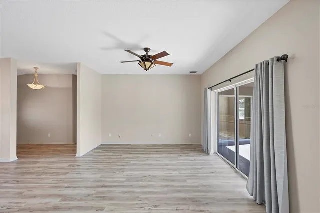 a view of a room with wooden floor and a ceiling fan
